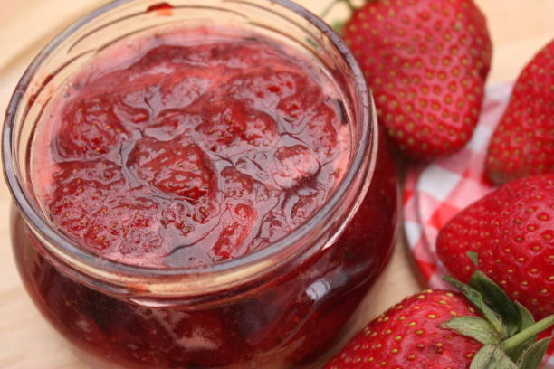 Strawberry sauce in a jar with fresh strawberries on the side