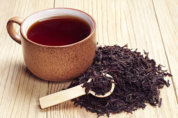 Black tea in a cup and dried leaves 