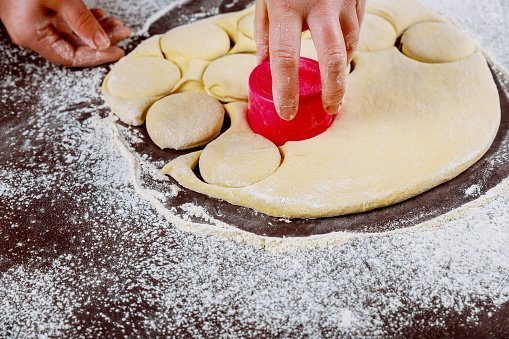 Cut out dough circles for making donuts.